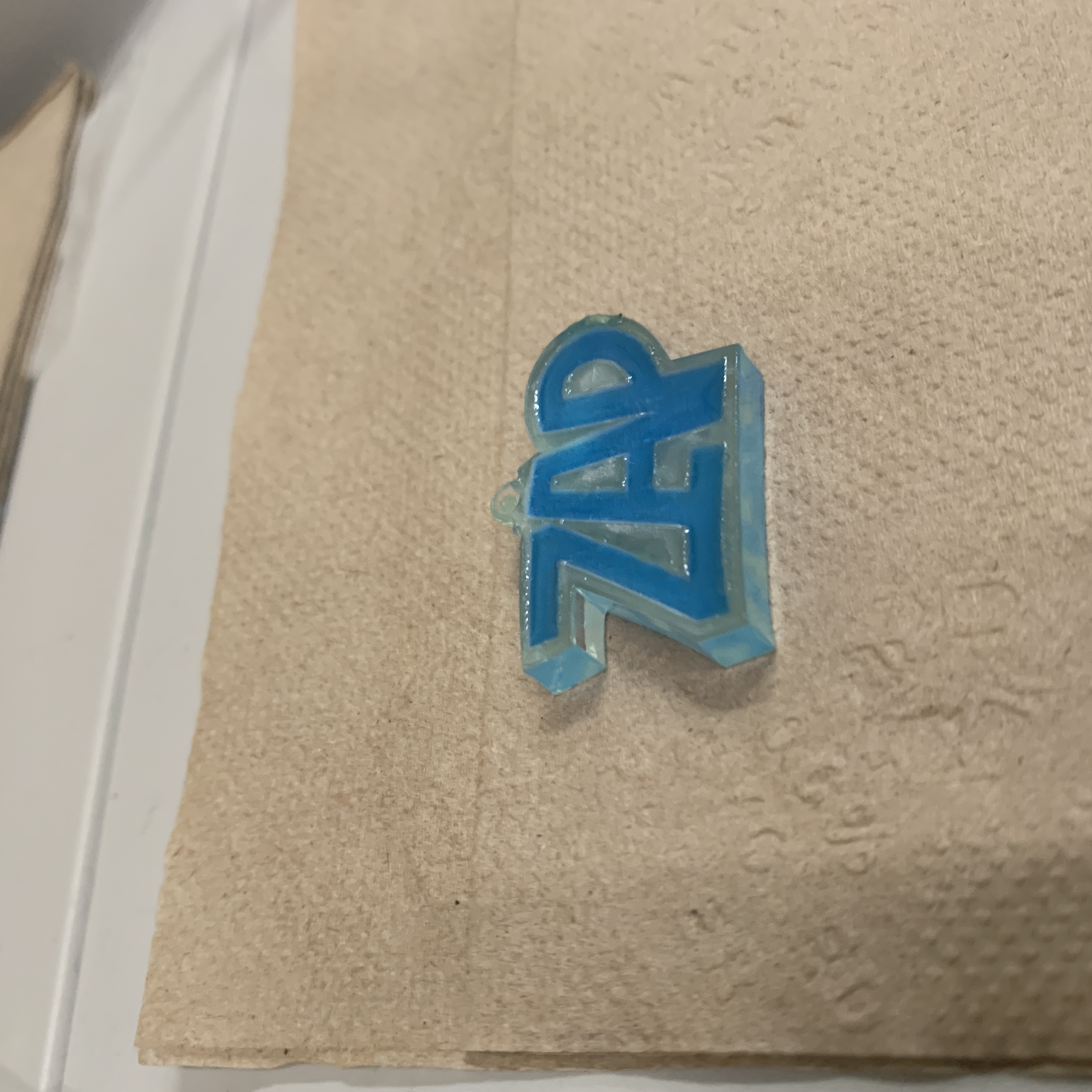 unfinished earring in clear acrylic with zap written in comic book in neon blue